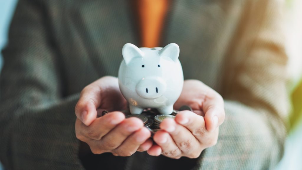 a woman holding piggy bank and coins in hands for saving money and financial concept